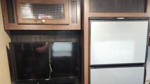 Une cuisine équipée d’un réfrigérateur encastré, d’un four à micro-ondes et d’une cuisinière.