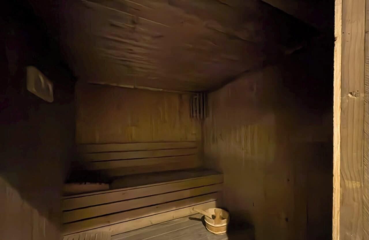 Un interior de madera con un banco y una pequeña mesa.