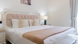 Ein Hotelzimmer mit einem großen Bett, einem Kopfteil, zwei Nachttischen und einem fenster mit Vorhängen.