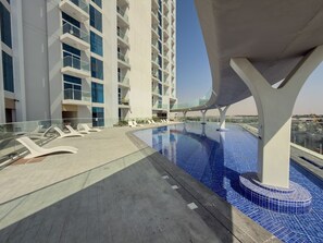 A rooftop pool with a clear view of a modern building in the background.