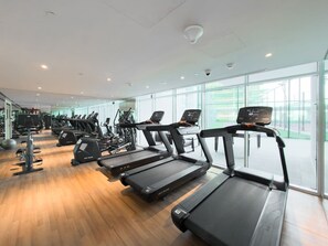 Ein Fitnessstudio mit Laufbändern, Ergometer und Gewichten.
