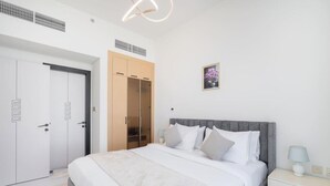 A bedroom with a bed, bedside tables, a wardrobe, and a picture on the wall. - Vogue, Arjan Skyz by Danube near Dubai Miracle Garden (Arjan)