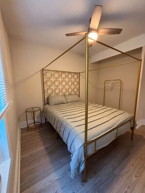 A four-poster bed with a geometric headboard, a ceiling fan, and a bedside table. - 2 Bedroom Poolside Escape Near Austin Hotspots (Austin)