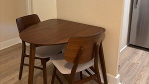 A dining area with a wooden table and chairs, a refrigerator, and a door leading to another room. - 2 Bedroom Poolside Escape Near Austin Hotspots (Austin)