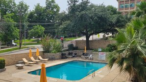 A rectangular swimming pool with a tiled deck, surrounded by lounge chairs and umbrellas. - 2 Bedroom Poolside Escape Near Austin Hotspots (Austin)