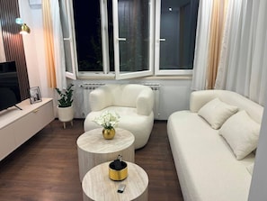 Ein modernes Wohnzimmer mit einer Couch, einem Sessel und einem Couchtisch.