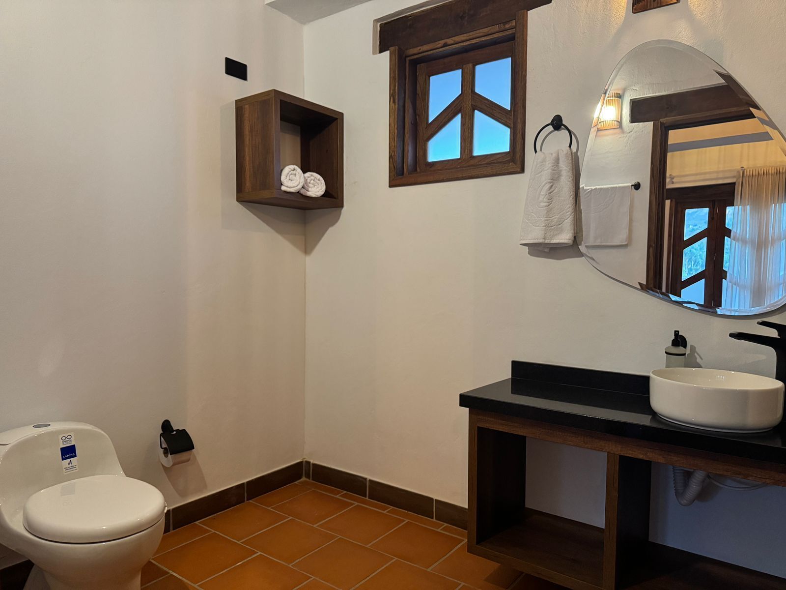 Baño con inodoro, lavabo y toallero.