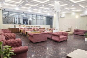 Un rebedor d'hotel modern amb seients confortables, una taquilla d'adreça i grans finestres.
