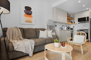Una sala de estar moderna con un sofá, una mesa de centro, una lámpara y una silla de comedor.