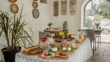 Una mesa de buffet con diferentes alimentos y una planta en maceta.