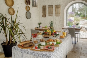 A buffet setup with various food items and a potted plant.