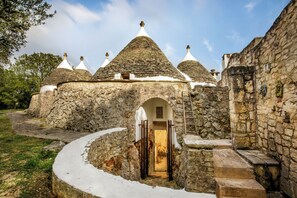 A stone building with multiple conical roofs and a central archway.
