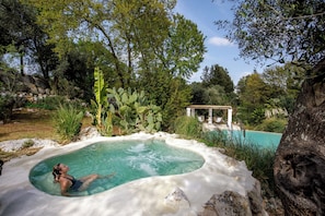 Una piscina al aire libre de temporada, sombrillas