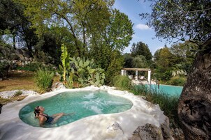 Una piscina al aire libre de temporada, sombrillas