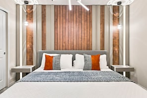 A modern bedroom with a bed, nightstands, and a wooden panel wall. - Orlando Most Incredible Themed 10BR Villa (Four Corners)