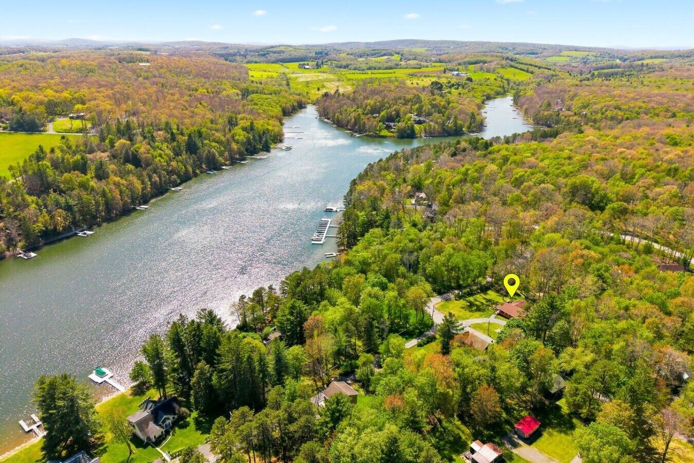 Een rivier met boten, omringd door beboste gebieden en huizen.