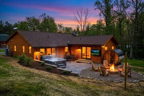 A log cabin with a hot tub, outdoor seating, and a fire pit. - Cozy Cabin, Sauna! Hot Tub! Filtered Lake Views! (Oakland)