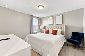 A hotel room with a bed, a desk, a chair, and two wall art pieces. - Themed 9BR Villa, Pool, Game Room, Champions Gate (Four Corners)