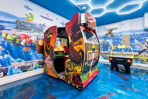 Une salle d’arcade sur le thème des dinosaures, avec une grande borne d’arcade dédiée aux dinosaures et une plus petite borne d’arcade classique.