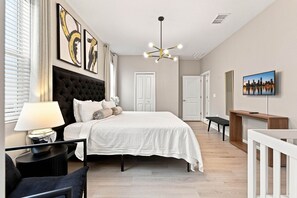 Une chambre à coucher moderne avec un grand lit, un bureau et un téléviseur.