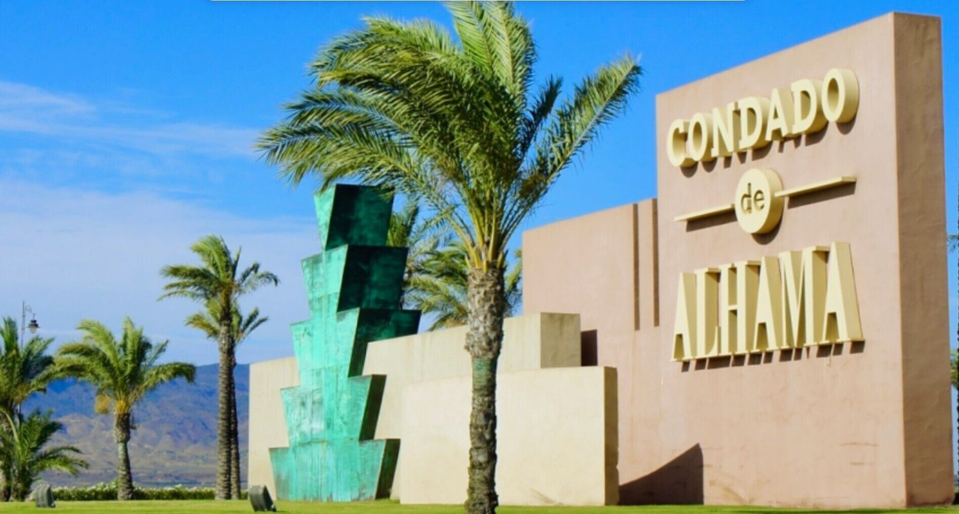 Un bâtiment portant une enseigne indiquant « CONDADO de ALHAMA » et une structure géométrique moderne située à proximité.