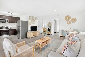A modern living room with a sofa, a coffee table, and a TV. - Modern Retreat Near Beach, Airport & Las Olas (Fort Lauderdale)