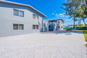 A modern building with a paved driveway, a covered entrance, and a picnic table. - Modern 2BR Near Beach, Airport & Las Olas (Fort Lauderdale)