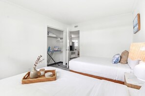 A hotel room with two beds, a small table with a tray of items, and a view of the hallway. - Modern 2BR Near Beach, Airport & Las Olas (Fort Lauderdale)