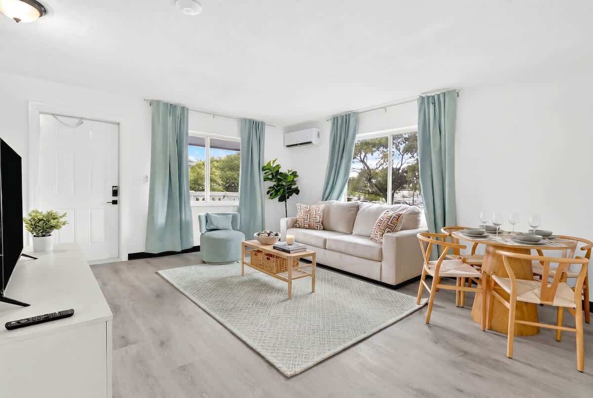 A modern living room with a sofa, coffee table, and dining area.