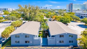 A hotel with a symmetrical design, two-story structure, and a parking lot in front. - Cozy 2BR Near Beach, Airport & Las Olas (Fort Lauderdale)