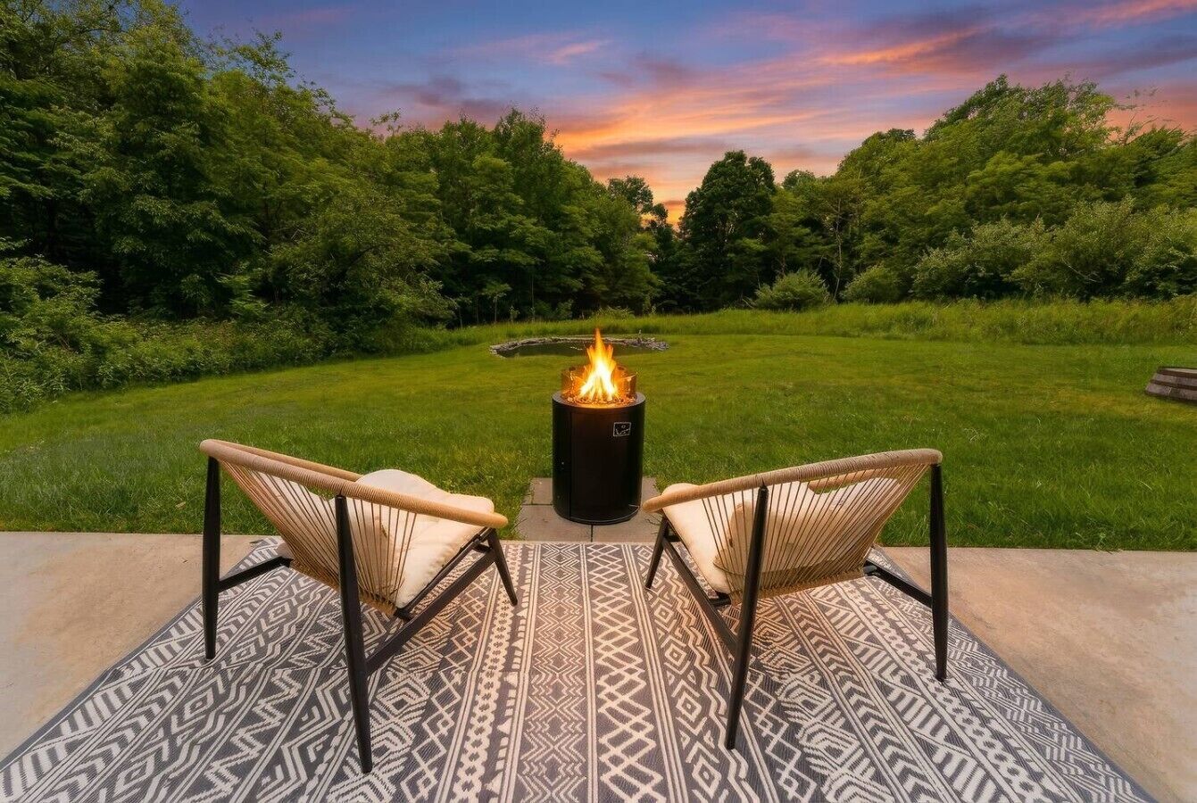 An outdoor seating area with two chairs and a fire pit.
