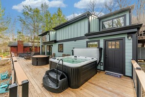 A house with a deck, hot tub, and outdoor seating area. - Lakefront! Sauna! HotTub! Sleeps 14! 1.5M to Wisp! (McHenry)
