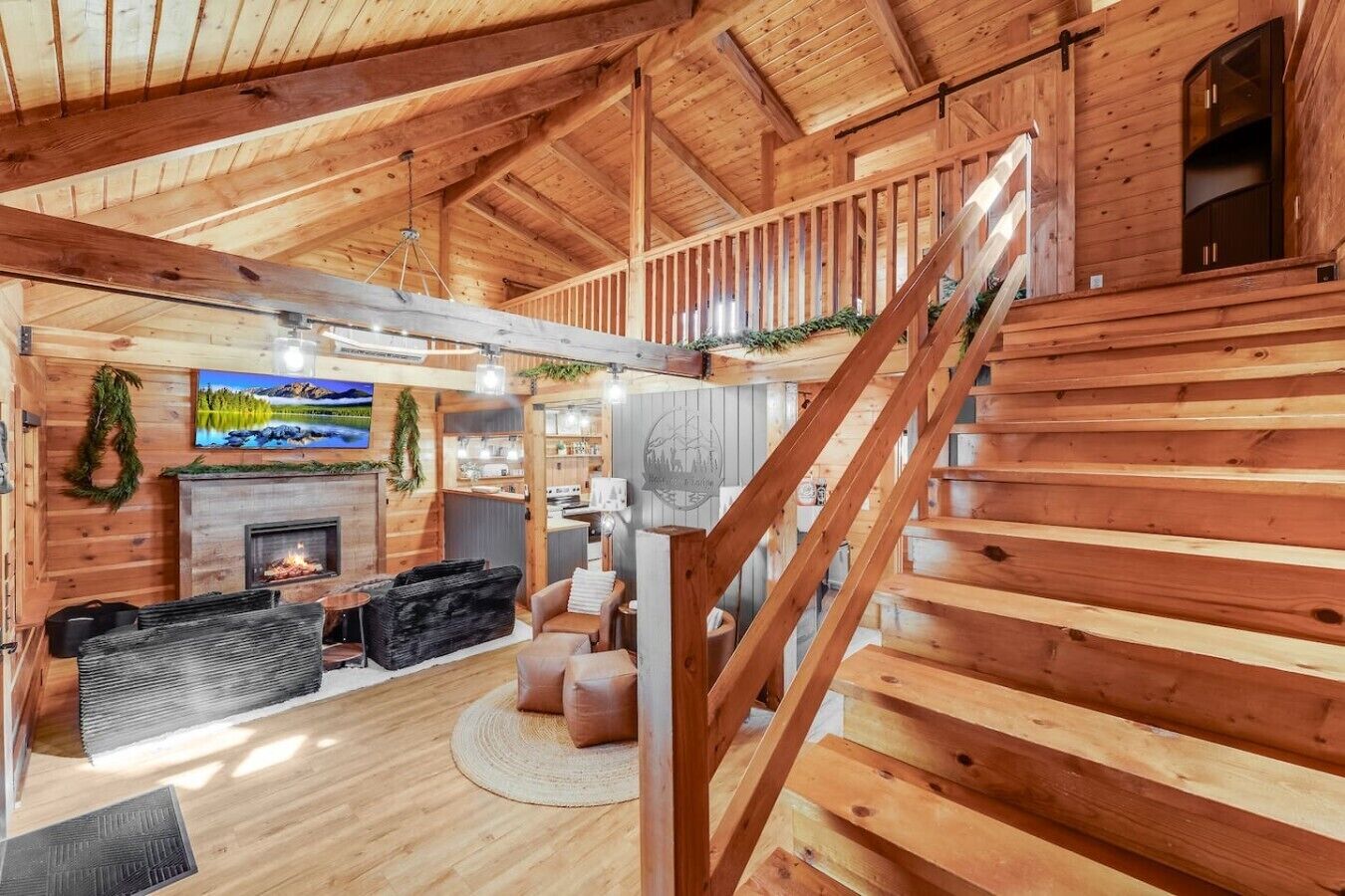 Interior em madeira com lareira, área de estar e escada.