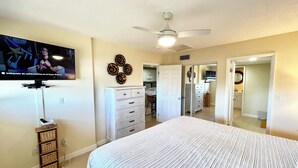 A bedroom with a bed, dresser, television, and a ceiling fan. - OV 123 Tennis Court View - Welcome To Paradise! (Fort Pierce)