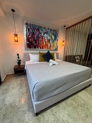 A modern bedroom with a large bed, a decorative wall art piece, and a unique lighting fixture. - Ground-Floor Studio · Terrace & Rooftop Pool (Playa del Carmen)