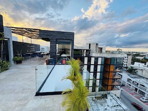 Eine moderne Dachterrasse mit Glasboden, Sitzgelegenheiten im Freien und Blick auf die Skyline.