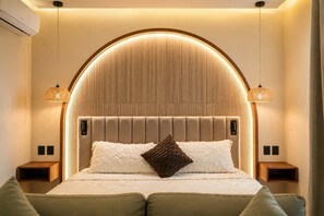 A bedroom with a large bed, a headboard with vertical lines, two bedside tables, and two hanging lamps. - Villa Sol | 2BR Ocean View & Pool | Isla Mujeres (Isla Mujeres)