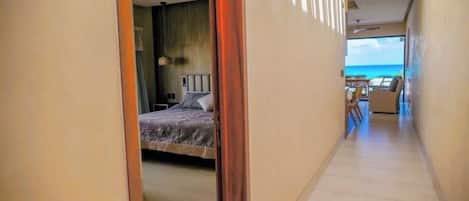 Une chambre d’hôtel avec un lit, une vue sur la plage et un balcon.