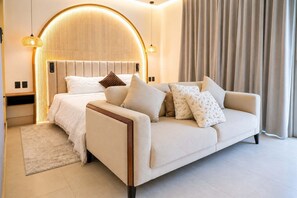 A modern bedroom with a bed, a sofa, and a large window with curtains. - Villa Sol | 2BR Ocean View & Pool | Isla Mujeres (Isla Mujeres)