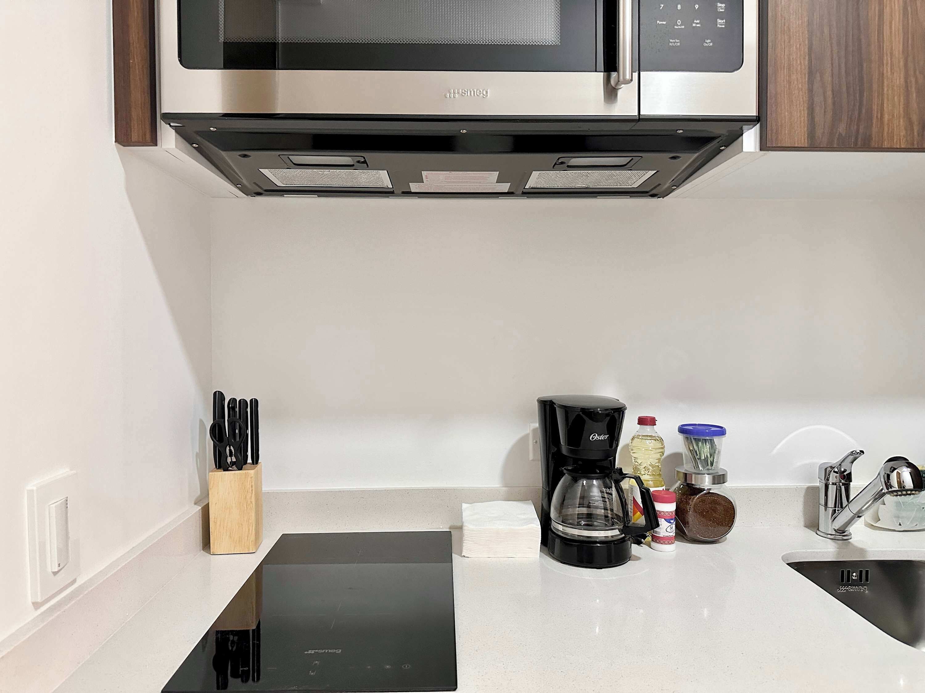 Cafetera o tetera, frigorífico, microondas y placa de cocina