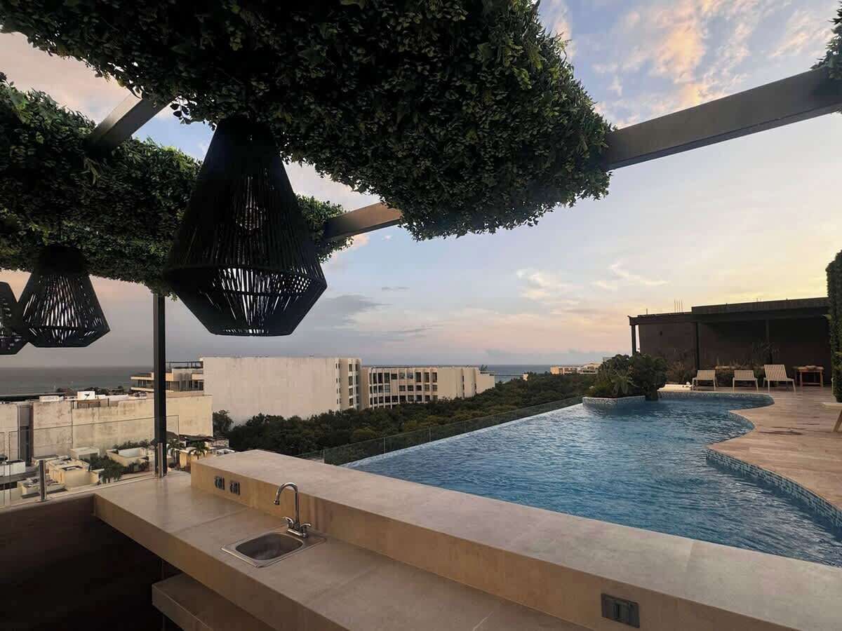 Piscina no terraço com vista para a cidade e o mar.