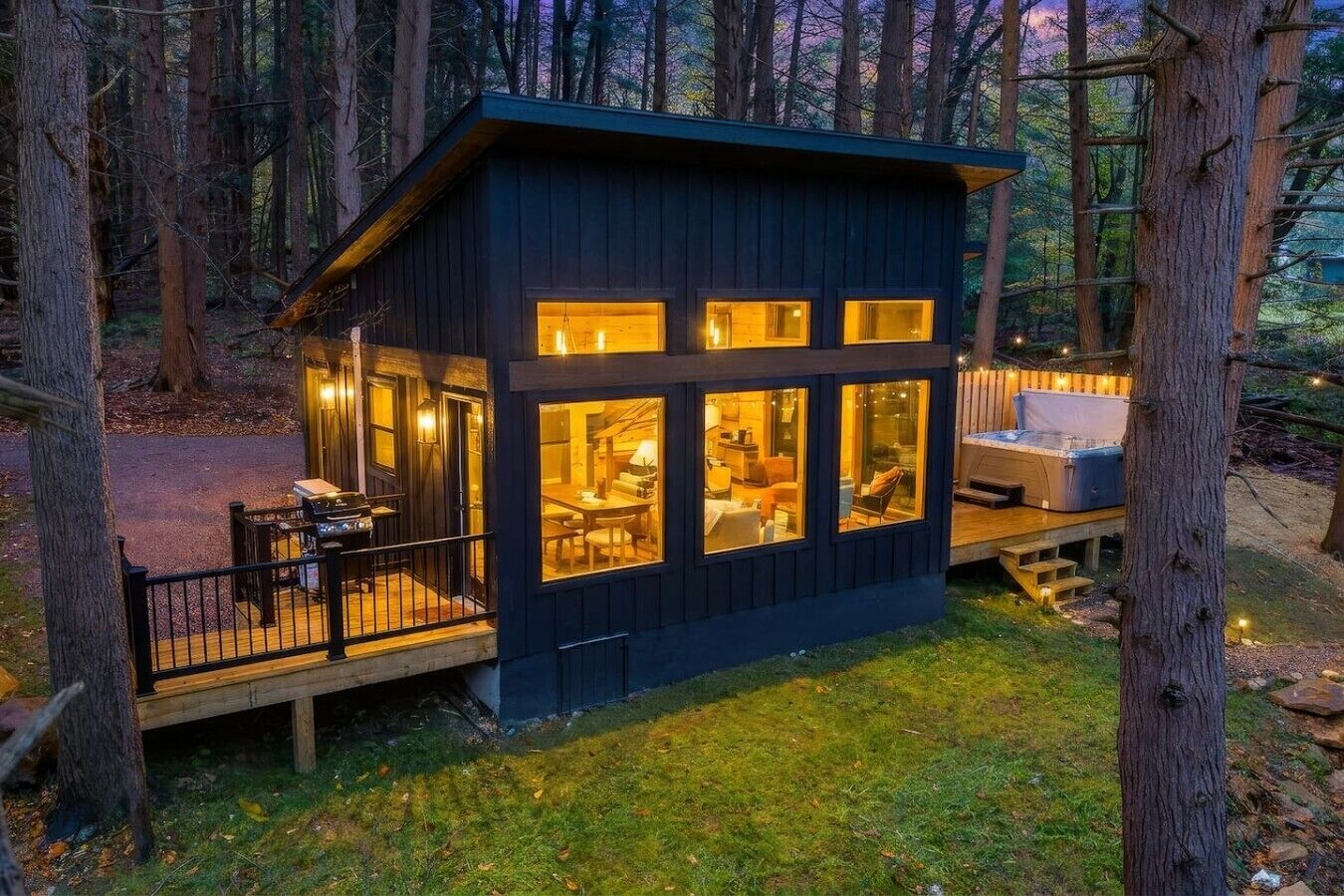 A cabin with a deck, a hot tub, and a dining area.