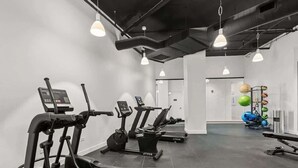 Uma academia com esteiras, elípticos e área para musculação.