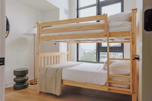 Ein Etagenbett mit Blick auf die Stadt durch große Fenster.