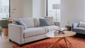 Uma sala de estar moderna com um sofá, uma mesa de centro e um tapete.