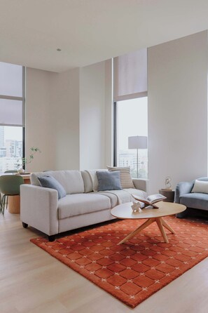 Ein modernes Wohnzimmer mit einer Couch, einem Couchtisch und einem Teppich.