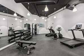 A gym with exercise equipment, a treadmill, and a bench. - Luxury Penthouse Collection PH2 - Fulton Market (Chicago)