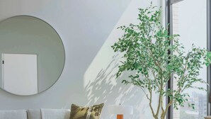 A modern living room with a sofa, coffee table, and a potted plant. - Luxury Penthouse Collection PH2 - Fulton Market (Chicago)