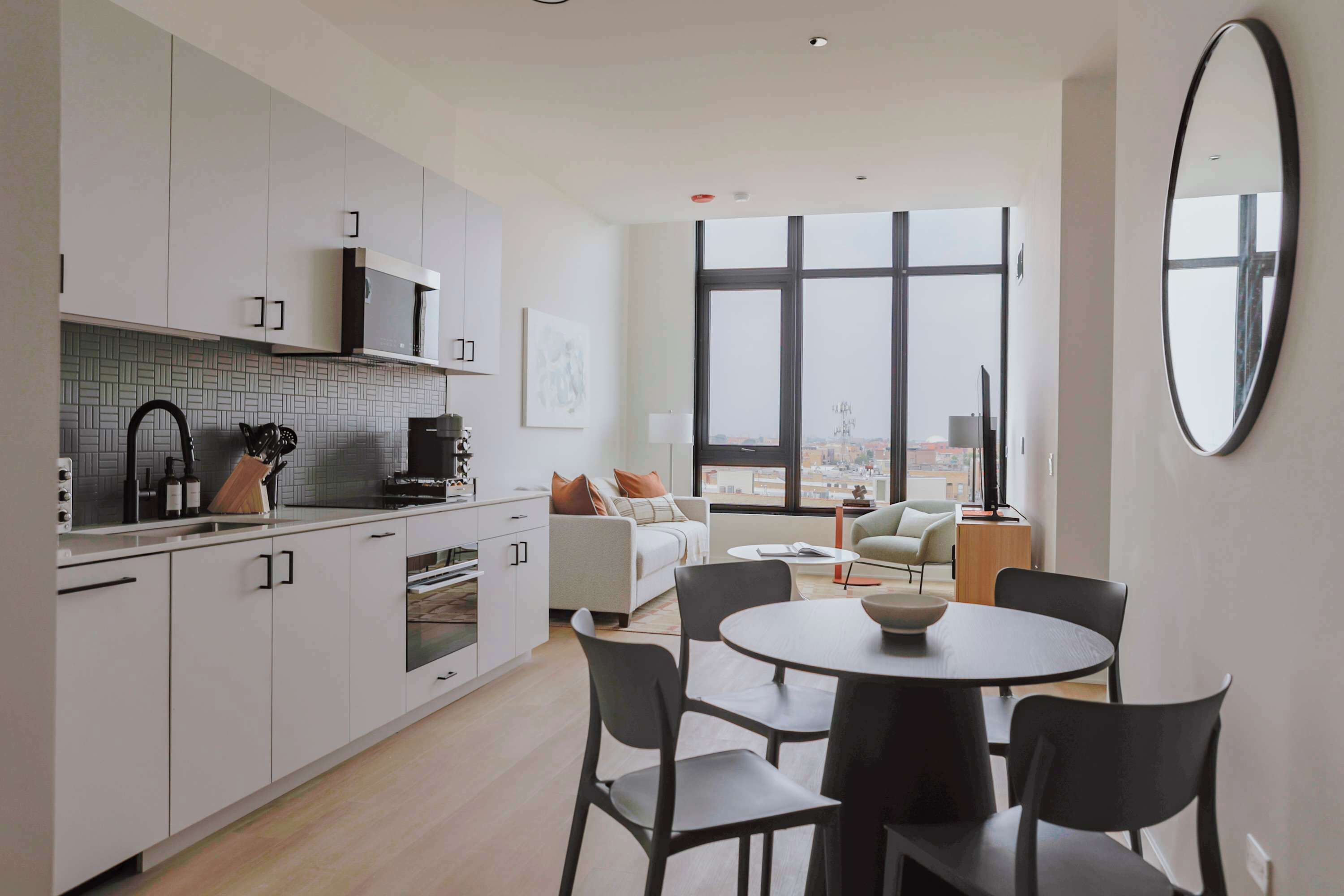 A modern apartment with a kitchen, dining area, and living room.