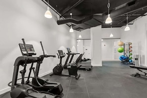 A gym with treadmills, elliptical machines, and a weightlifting area. - Luxury Penthouse Collection PH3 - Fulton Market (Chicago)